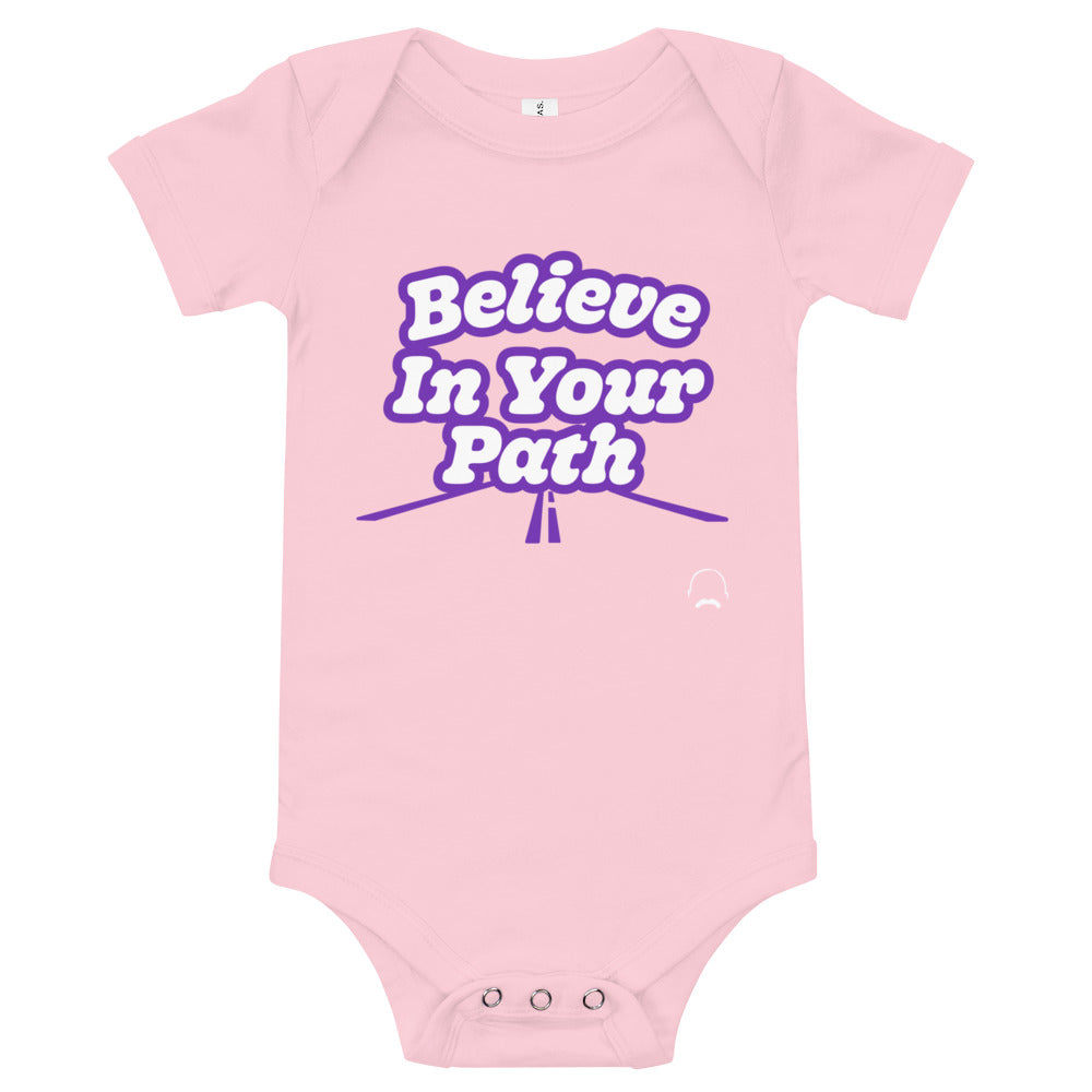 
                  
                    Load image into Gallery viewer, Pink baby onesie with Believe In Your Path text in white with purple outline and a road graphic at the bottom with Steve Harvey Head and Mustache outline in bottom corner
                  
                