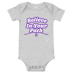 
                  
                    Load image into Gallery viewer, Grey baby onesie with Believe In Your Path text in white with purple outline and a road graphic at the bottom with Steve Harvey Head and Mustache outline in bottom corner
                  
                