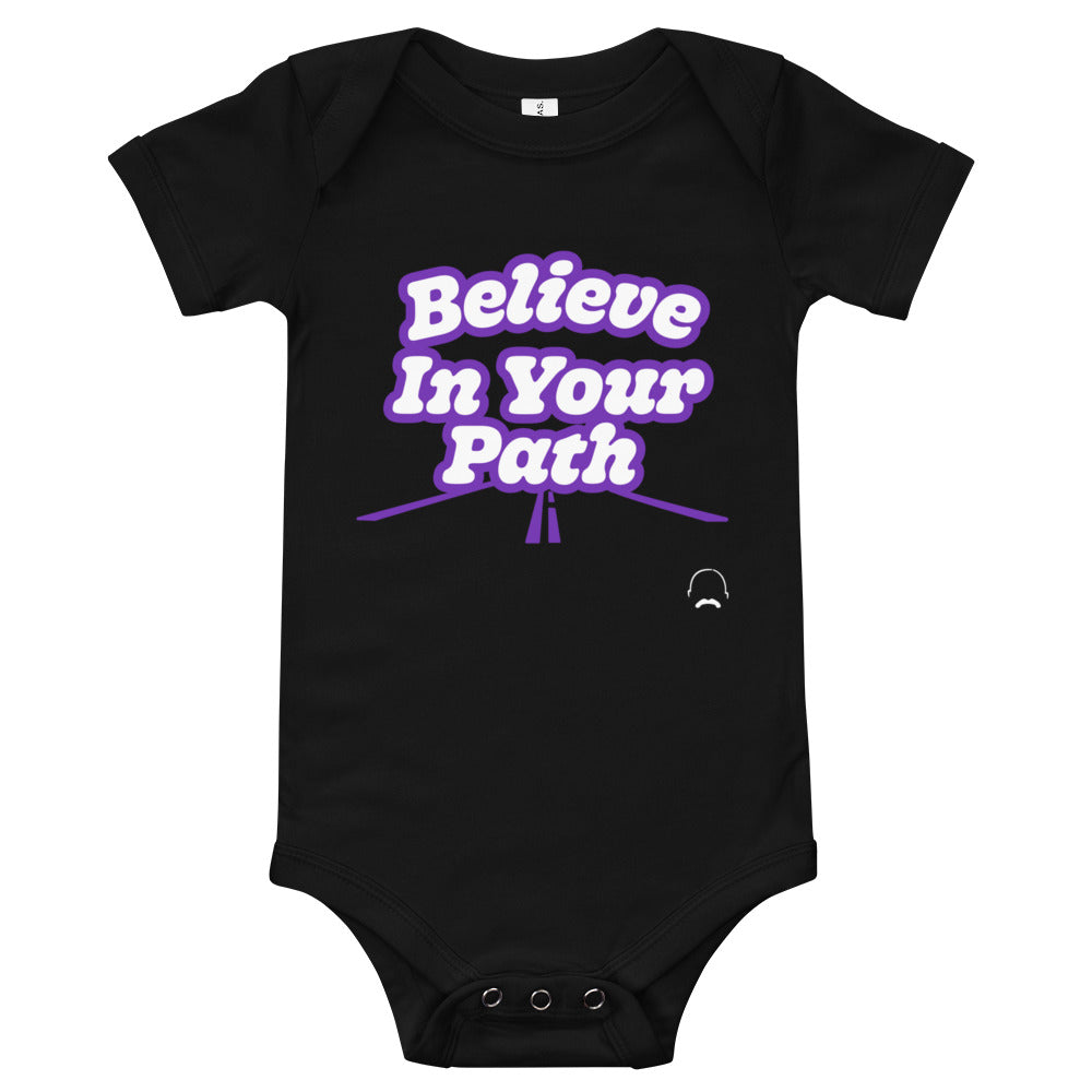 
                  
                    Load image into Gallery viewer, Black baby onesie with Believe In Your Path text in white with purple outline and a road graphic at the bottom with Steve Harvey Head and Mustache outline in bottom corner
                  
                