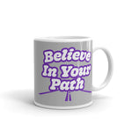 11 oz White coffee mug with Blieve In Your Path text in white with purple outline and road graphic on grey background