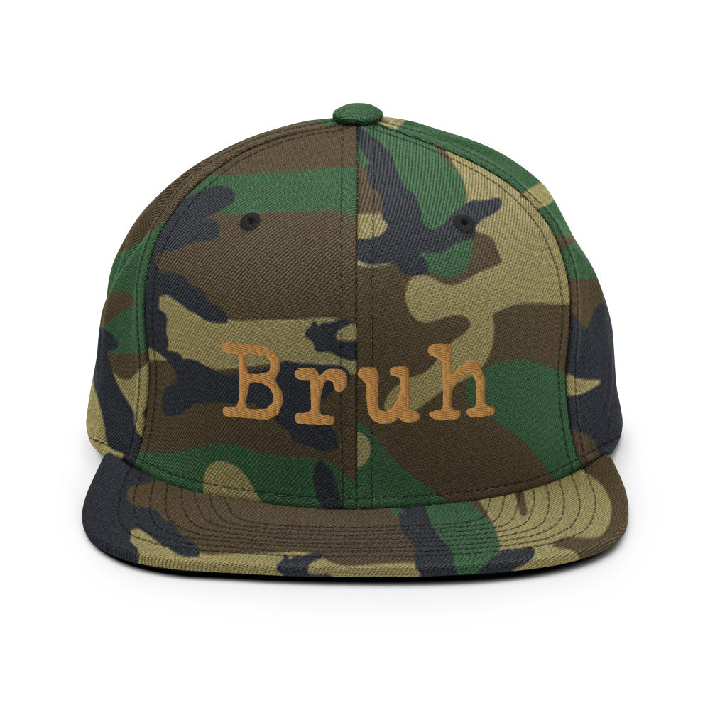 
                  
                    Load image into Gallery viewer, Camouflauge Snapback hat with the word &amp;quot;Bruh&amp;quot; in Brown typewriter text on the front
                  
                